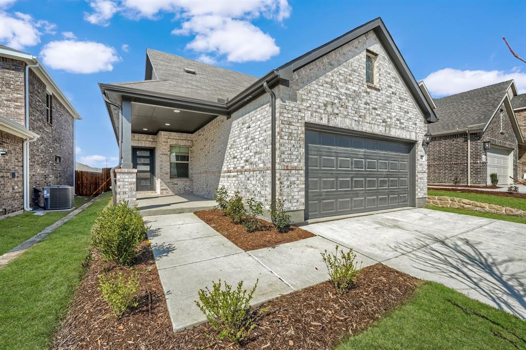 View of front of home featuring cooling unit, concrete driveway, an attached garage, a front lawn, and a shingled roof