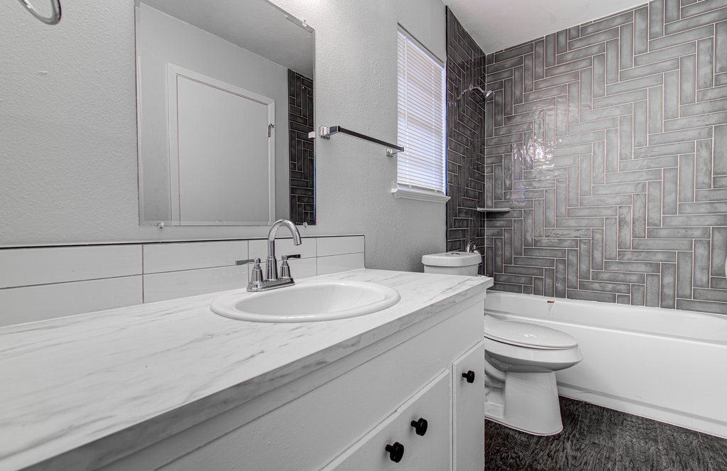 5703 Gloucester Lane, Unit A Austin, TX 78723 - Photo 10 of 11 a bathroom with a sink a toilet and a bathtub