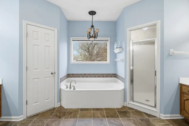 a bathroom with a tub sink and mirror