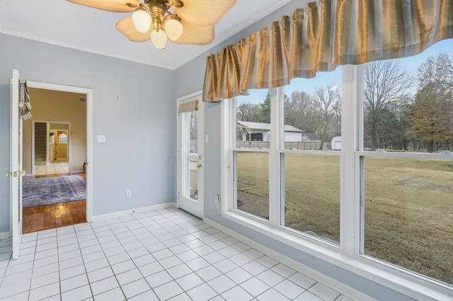 an empty room with windows and fan