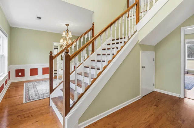 a view of staircase with wooden floor and white walls