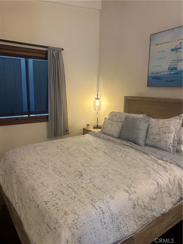 a large bed in a bedroom next to a cabinet
