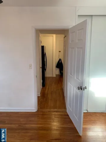 a view of a hallway with wooden floor and closet