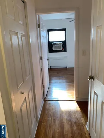 a view of a hallway and wooden floor with a living room