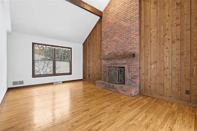 a view of an empty room with a fireplace and a window