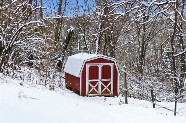 a front view of a house with a yard covered with snow