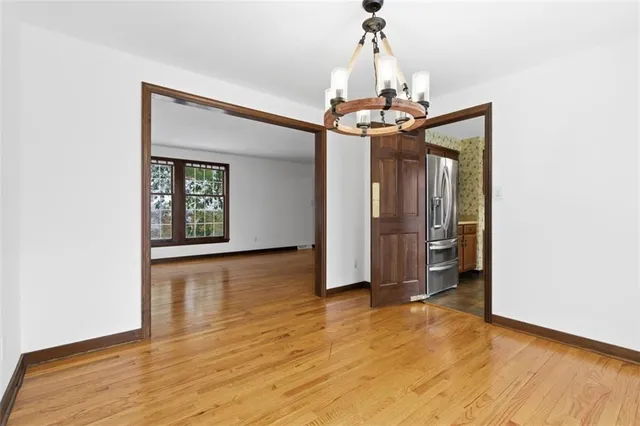 a view of a livingroom with a chandelier and wooden floor