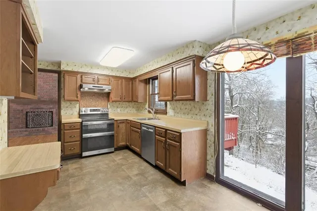 a large kitchen with stainless steel appliances granite countertop a stove and a refrigerator