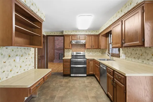 a kitchen with stainless steel appliances a stove sink and cabinets