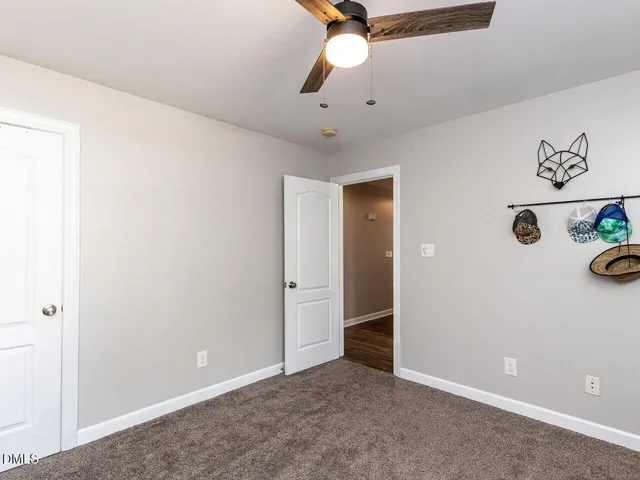an empty room with cabinets and fan