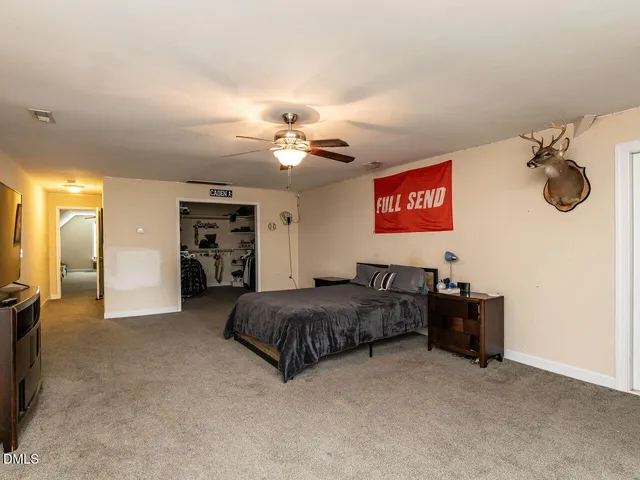 a spacious bedroom with a bed and ceiling fan