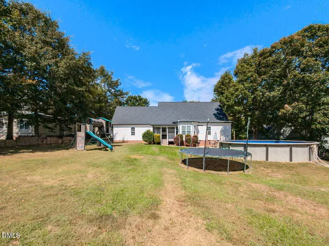 a view of a house with pool and chairs