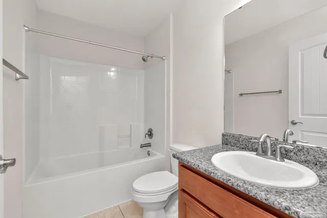 a bathroom with a granite countertop sink toilet mirror and shower
