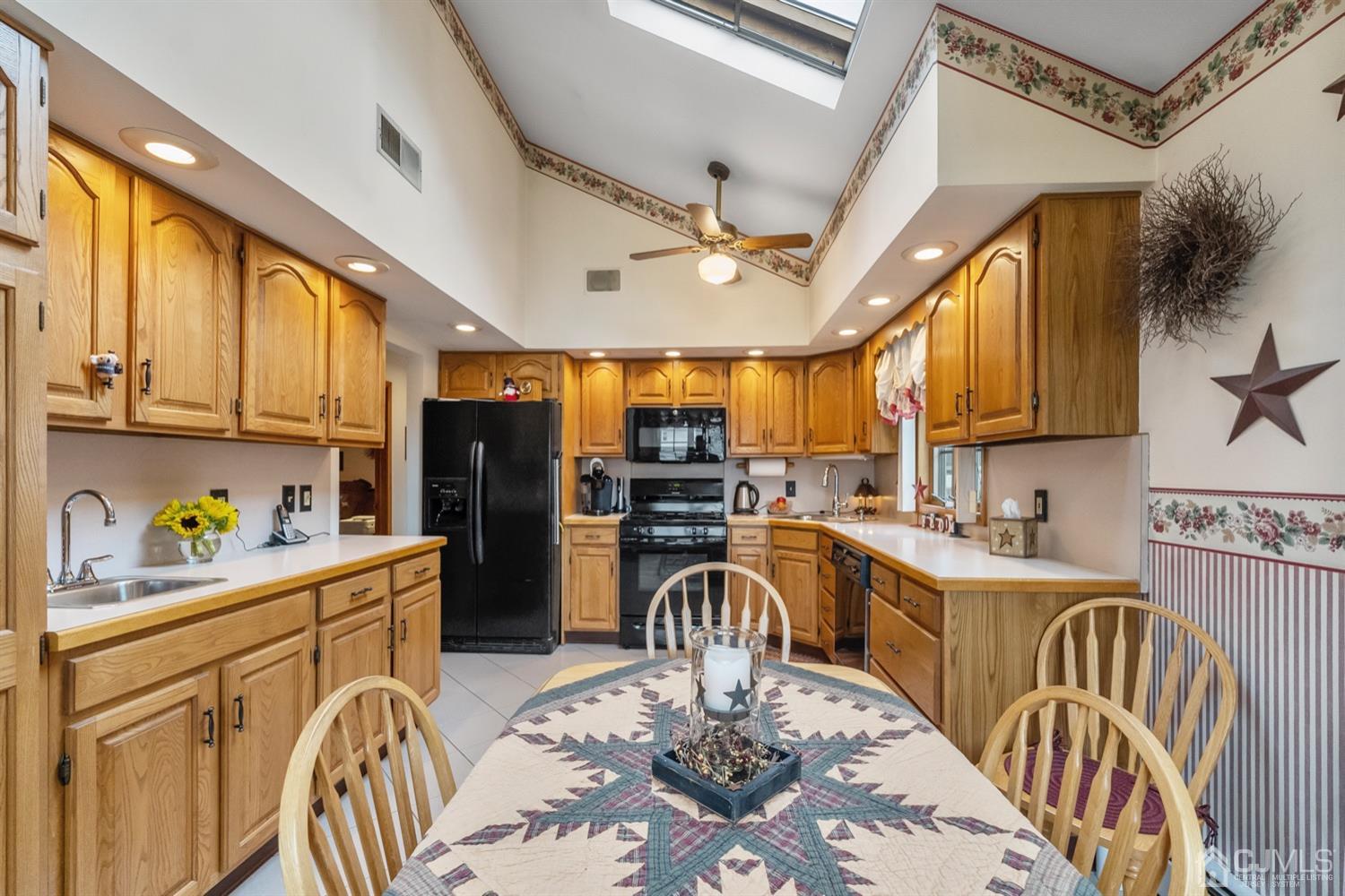 78 Highfield Road Colonia, NJ 07067 - Photo 2 of 8 a kitchen with stainless steel appliances granite countertop a refrigerator a sink a stove a dining table and chairs with wooden floor