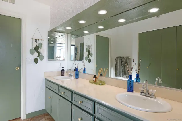 a bathroom with double vanity sinks and a large mirror