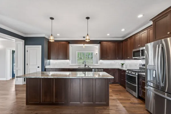 a kitchen with granite countertop stainless steel appliances a refrigerator and a sink