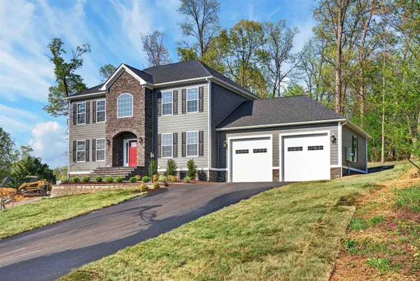 a kitchen with stainless steel appliances granite countertop wooden floors wooden cabinets a sink and a island
