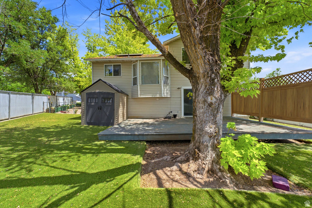 2475 Church Street Layton, UT 84040 - Photo 24 of 27 Spacious backyard featuring a large tree, green lawn, and an expansive deck