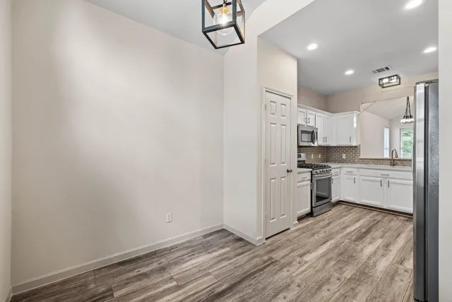 a kitchen with white cabinets and white appliances