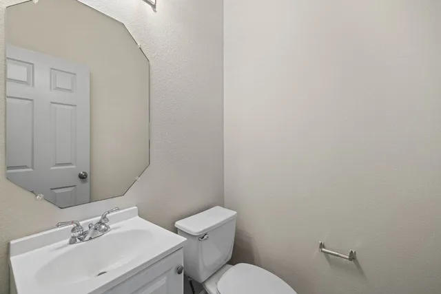a bathroom with a sink mirror and toilet
