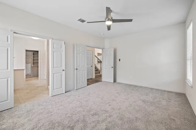 an empty room with fan and entrance