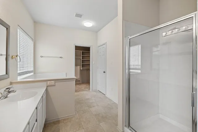 a bathroom with a tub sink and mirror