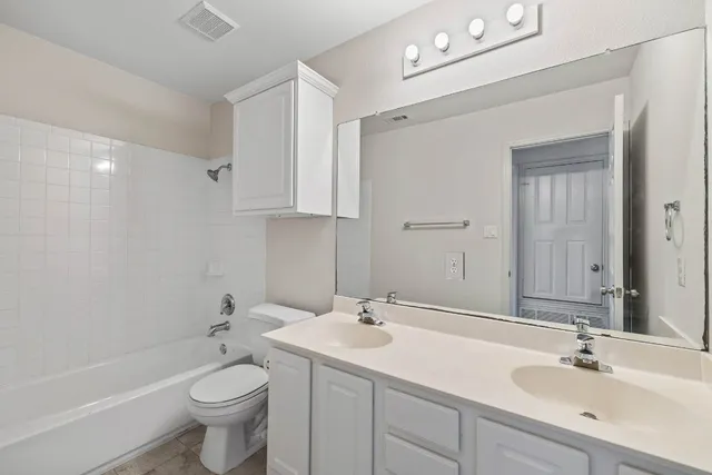 a bathroom with a double vanity sink toilet and shower