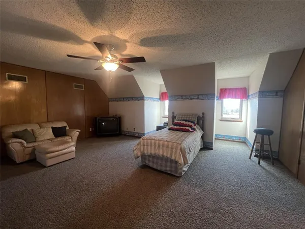 a spacious bedroom with a bed and a chandelier