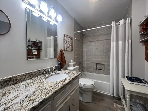 a bathroom with a granite countertop sink toilet and shower
