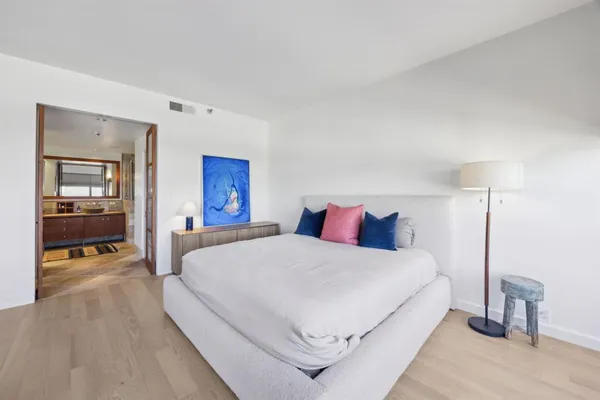 a bedroom with a large bed and a large mirror