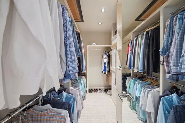 a view of walk in closet with clothes and shoes