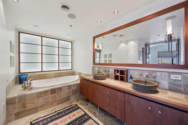 a bathroom with a double vanity sink and a bathtub