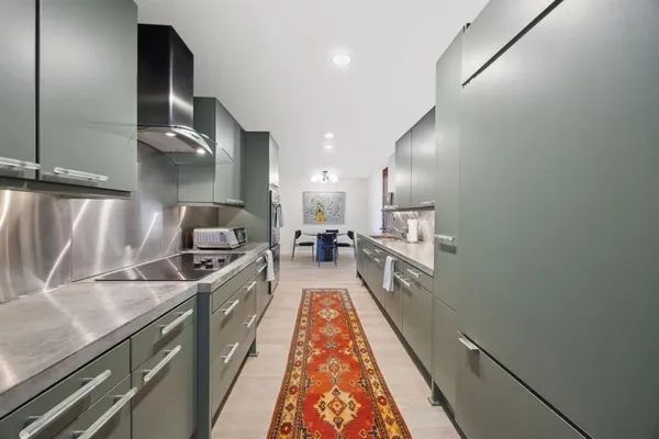 a large kitchen with stainless steel appliances granite countertop a stove a sink and a refrigerator
