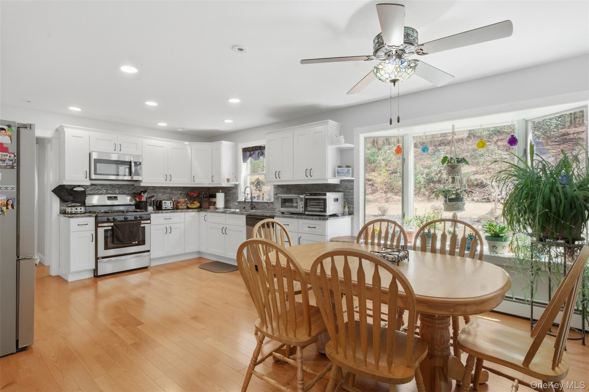 1285 Lakes Road Monroe, NY 10950 - Photo 4 of 45 a kitchen with stainless steel appliances granite countertop a stove a refrigerator a kitchen island a dining table and chairs