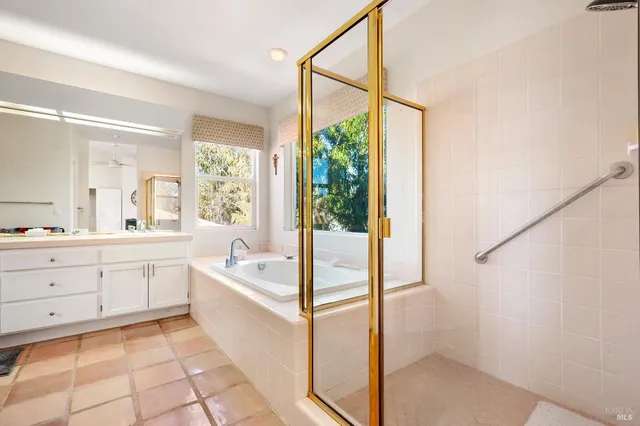 a spacious bathroom with a tub sink and mirror