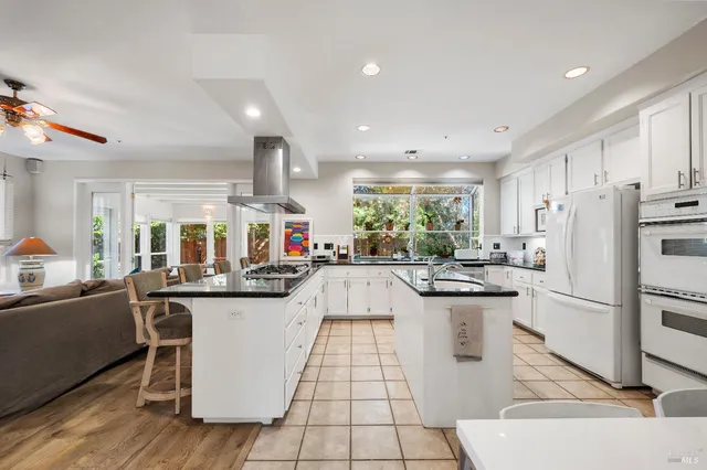 a kitchen with stainless steel appliances kitchen island granite countertop a sink and cabinets
