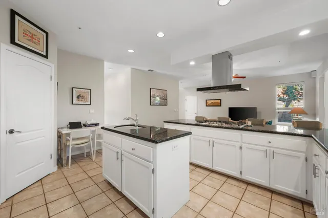 a kitchen with white cabinets and sink