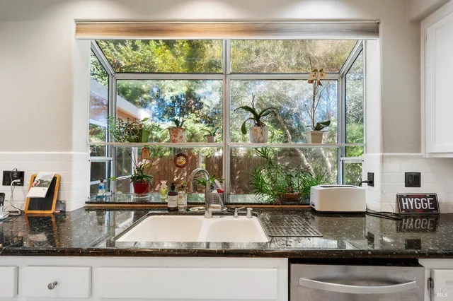 a kitchen with kitchen island granite countertop a large window