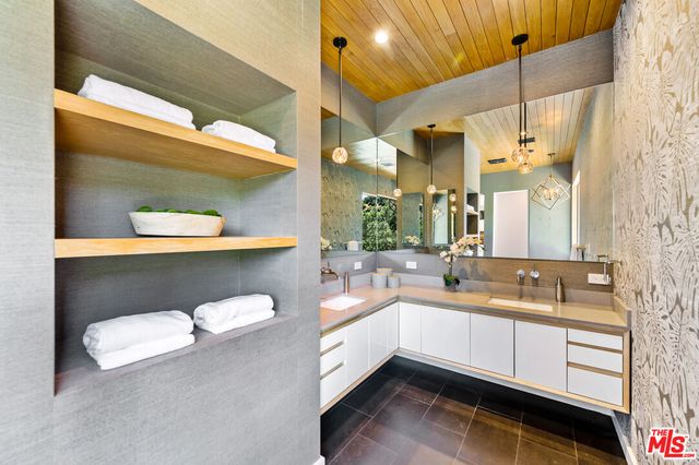 a spacious bathroom with a double vanity sink a mirror and a bathtub