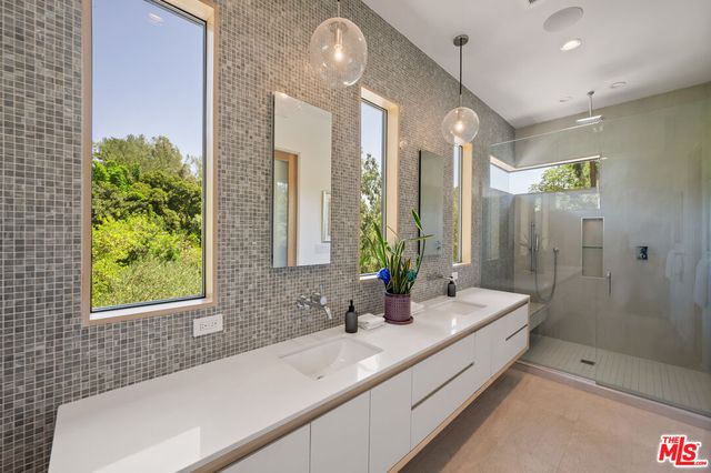 a bathroom with a double vanity sink and large mirror