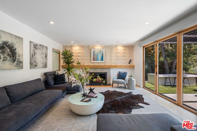 a living room with furniture a fireplace and a large window