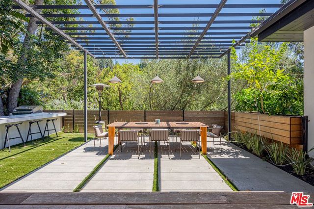 a view of a patio with table and chairs potted plants with wooden floor and fence
