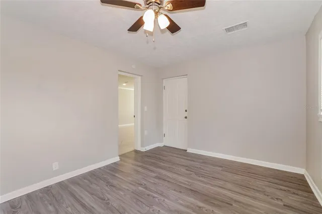a view of an empty room with wooden floor