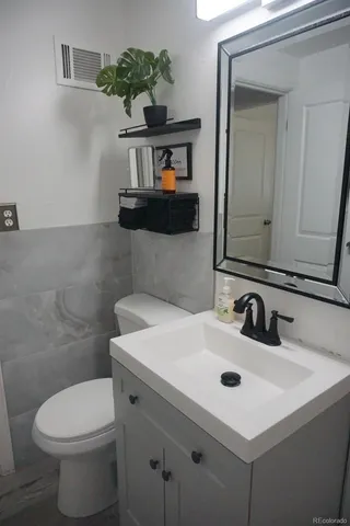 a bathroom with a sink a toilet and mirror