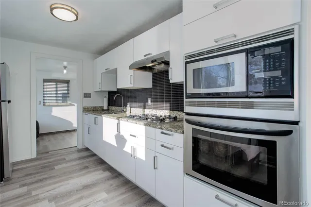 a kitchen with stainless steel appliances granite countertop a stove and cabinets