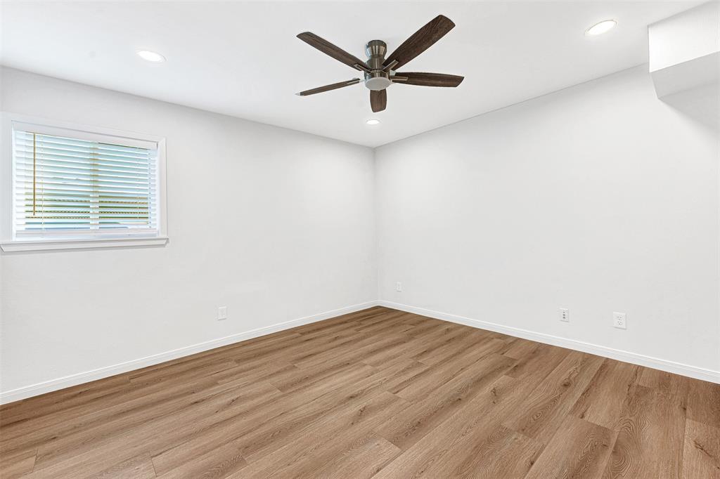 2809 Rio Branco Street, Unit 102 Farmers Branch, TX 75234 - Photo 13 of 21 an empty room with wooden floor and windows