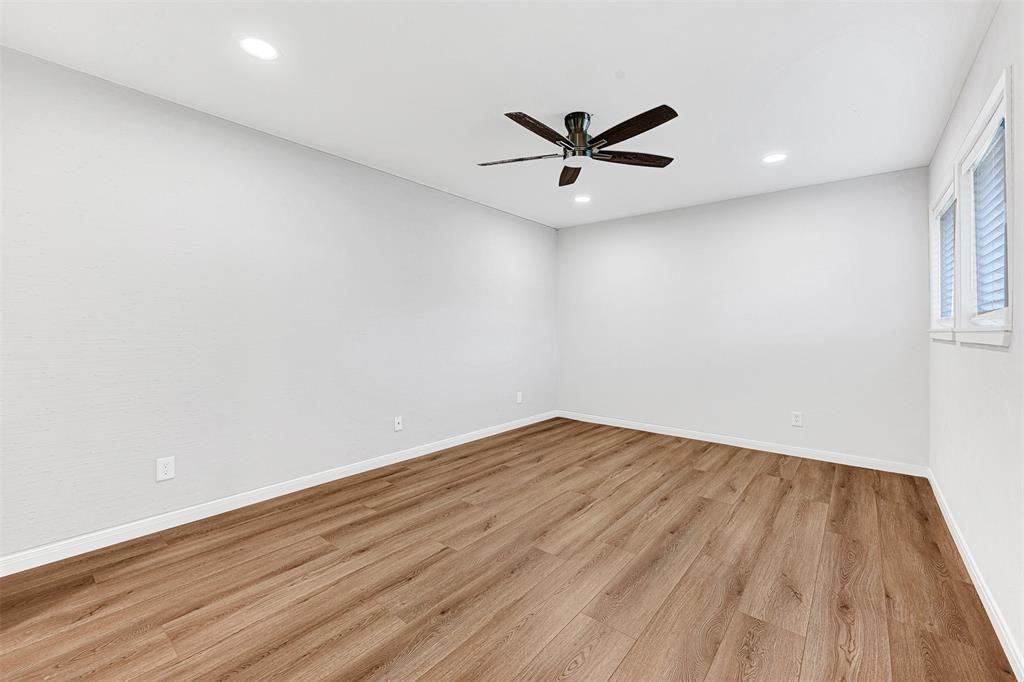 2809 Rio Branco Street, Unit 102 Farmers Branch, TX 75234 - Photo 15 of 21 a view of a big room with wooden floor and a ceiling fan