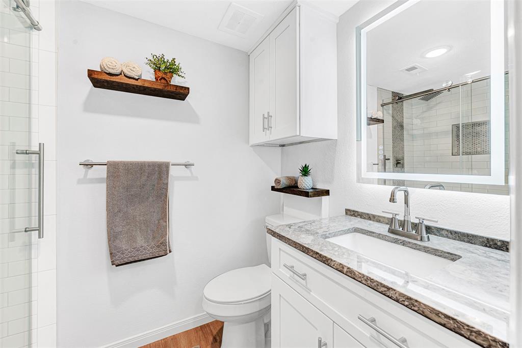 2809 Rio Branco Street, Unit 102 Farmers Branch, TX 75234 - Photo 18 of 21 a bathroom with a granite countertop sink mirror vanity and toilet