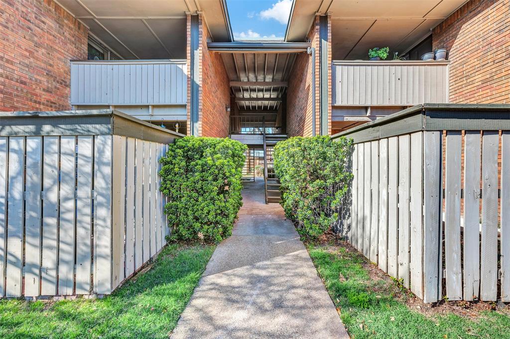 2809 Rio Branco Street, Unit 102 Farmers Branch, TX 75234 - Photo 2 of 21 a view of a brick house with wooden fence