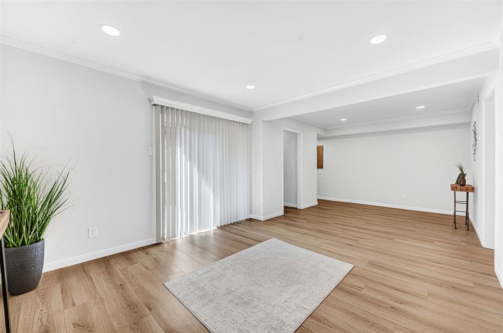 2809 Rio Branco Street, Unit 102 Farmers Branch, TX 75234 - Photo 7 of 21 a view of an empty room with wooden floor and a potted plant